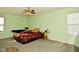 Bedroom with neutral carpet, a ceiling fan, and light green walls at 9955 Orange Blossom Trl, Fishers, IN 46038