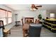 Dining room with wood-look floors, a wooden dining table, a ceiling fan, and bright natural light at 9955 Orange Blossom Trl, Fishers, IN 46038