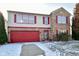 Charming two-story home featuring a red garage door, red shutters, brick accents, and a well-maintained front yard at 9955 Orange Blossom Trl, Fishers, IN 46038