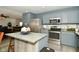 Updated kitchen with stainless steel appliances, gray cabinets, and center island ready for cooking at 9955 Orange Blossom Trl, Fishers, IN 46038