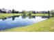 Scenic view of a tranquil pond reflecting the sky, framed by lush greenery and surrounding homes at 10267 Ranford Blvd, Fishers, IN 46040