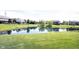 A tranquil backyard featuring a pond with homes in the background, complemented by a lush green lawn at 10267 Ranford Blvd, Fishers, IN 46040