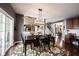 Cozy dining area with dark wood table and chairs, a large area rug, and a view of the living room at 10267 Ranford Blvd, Fishers, IN 46040