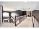 Bright hallway featuring neutral carpet, decorative wood railing, and access to multiple rooms at 10267 Ranford Blvd, Fishers, IN 46040