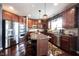 Bright kitchen featuring a stainless refrigerator, wood cabinets, an island, and modern lighting at 10267 Ranford Blvd, Fishers, IN 46040