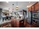 Large kitchen features stainless appliances, dark wood cabinetry, and an island with granite countertops and eat-in seating at 10267 Ranford Blvd, Fishers, IN 46040