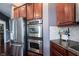 Gourmet kitchen with stainless steel appliances including double oven and plenty of dark wood cabinet storage at 10267 Ranford Blvd, Fishers, IN 46040