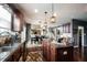 Stylish kitchen featuring an island, stainless steel appliances, wood cabinets, granite countertops, and modern lighting at 10267 Ranford Blvd, Fishers, IN 46040