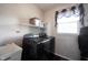 Functional laundry room with modern black washer and dryer, sink, shelving and window at 10267 Ranford Blvd, Fishers, IN 46040