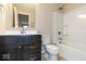 Bathroom with dark wood vanity, white toilet and tub with shower at 10307 Gateway Dr, Brownsburg, IN 46234