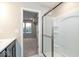 Modern bathroom featuring a glass door shower and doorway to carpeted bedroom at 10307 Gateway Dr, Brownsburg, IN 46234