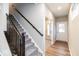 Hallway with carpeted stairs, hardwood floor, and a white door to the outside at 10307 Gateway Dr, Brownsburg, IN 46234