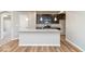 Bright kitchen featuring a center island with sink, granite countertops, and dark cabinetry at 10307 Gateway Dr, Brownsburg, IN 46234
