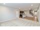 Open-concept living room with dark cabinetry in the kitchen and staircase access at 10307 Gateway Dr, Brownsburg, IN 46234