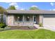 Inviting front porch with brick and blue wood details, landscaping, and flower pots at 10363 N County Road 950 E, Brownsburg, IN 46112