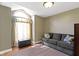 Cozy living room with a large arched window, sofa, ottoman, and hardwood floors at 10363 N County Road 950 E, Brownsburg, IN 46112