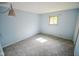 Bedroom with pastel blue walls, patterned carpet, and one window offering natural light at 10827 Wonderland Dr, Indianapolis, IN 46239