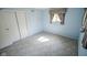 Bedroom with pastel blue walls, patterned carpet, and closet with sliding doors at 10827 Wonderland Dr, Indianapolis, IN 46239