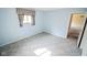 Bedroom with pastel blue walls, patterned carpet, and natural light from the window at 10827 Wonderland Dr, Indianapolis, IN 46239