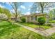 Beautiful stone home featuring a lamp post, trimmed bushes, and well kept lawn at 10827 Wonderland Dr, Indianapolis, IN 46239