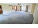 Open living room with plush carpet, large windows, and seamless flow into kitchen at 10827 Wonderland Dr, Indianapolis, IN 46239