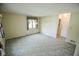 Spacious living room with neutral paint, patterned carpet, and natural light from the window at 10827 Wonderland Dr, Indianapolis, IN 46239