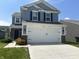 Charming two-story home featuring light blue siding, a two-car garage, and a well-manicured front lawn on a sunny day at 10835 Spirit Dr, Ingalls, IN 46048