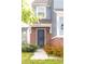 Inviting front entrance with a stylish dark blue door, brick accents, and manicured landscaping at 10835 Spirit Dr, Ingalls, IN 46048