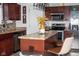 Modern kitchen featuring an island with seating, stainless steel appliances, and dark wood cabinetry at 10835 Spirit Dr, Ingalls, IN 46048