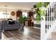 Open-concept living area featuring a stylish sofa, hardwood floors, and stairs with white railing at 10835 Spirit Dr, Ingalls, IN 46048