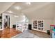 Spacious attic featuring hardwood floors, bookshelves, with an adjacent closet, a mini split, and natural lighting at 1107 N Hartman Dr, Indianapolis, IN 46219