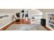 Spacious attic with hardwood floors, bookshelves, and an area for relaxation with a view of a bedroom at 1107 N Hartman Dr, Indianapolis, IN 46219