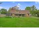 The back of the home sits on a spacious yard and a sunroom at 1107 N Hartman Dr, Indianapolis, IN 46219