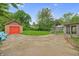 Spacious backyard featuring a detached garage, trampoline, and patio area with seating at 1107 N Hartman Dr, Indianapolis, IN 46219
