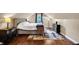 A cozy bedroom featuring hardwood floors, a tufted headboard bed, a window view, and ample storage at 1107 N Hartman Dr, Indianapolis, IN 46219