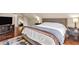 A comfortable bedroom with hardwood floors, a tufted headboard bed, a mirror and ample storage space at 1107 N Hartman Dr, Indianapolis, IN 46219