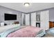 Light filled bedroom showing two closets, bureau, and hardwood flooring at 1107 N Hartman Dr, Indianapolis, IN 46219