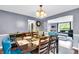 Dining room with a wooden table, blue chairs, and an open view to the adjacent living room at 1107 N Hartman Dr, Indianapolis, IN 46219