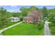 Charming home with well-manicured lawn, mature trees, and driveway at 1107 N Hartman Dr, Indianapolis, IN 46219