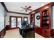 This home office offers custom wood built-ins, a ceiling fan, French doors, and a spacious work area at 11319 Shoreview Ln, Indianapolis, IN 46236