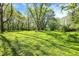 Large, mostly level backyard covered with lush green grass and mature trees at 11471 Clarkston Rd, Zionsville, IN 46077