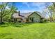 Large backyard with mature trees, gazebo, and patio with outdoor seating under a blue umbrella at 11471 Clarkston Rd, Zionsville, IN 46077