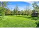 Large grassy backyard with mature trees and a gazebo in the distance at 11471 Clarkston Rd, Zionsville, IN 46077