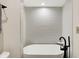 Bathroom with modern tub, minimalist faucet and gray tiled walls at 11471 Clarkston Rd, Zionsville, IN 46077