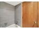 Bathroom with gray tiled walls, a tub and a shower at 11471 Clarkston Rd, Zionsville, IN 46077