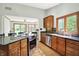 Open kitchen with granite countertops, stainless steel appliances, wooden cabinets and wood flooring at 11471 Clarkston Rd, Zionsville, IN 46077