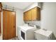 Bright laundry room with modern washer and dryer, cabinetry, and a utility sink at 11471 Clarkston Rd, Zionsville, IN 46077