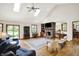 Bright living room featuring skylights, a brick fireplace, and hardwood floors at 11471 Clarkston Rd, Zionsville, IN 46077