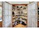 Walk-in pantry with wood shelves and storage space behind white lace curtains at 11471 Clarkston Rd, Zionsville, IN 46077