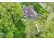 Aerial view of a backyard featuring an outdoor dining area, a hot tub, mature trees, and green space at 11550 Clarkston Rd, Zionsville, IN 46077